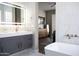 Modern bathroom featuring a gray vanity with a light-up mirror and a freestanding white tub at 25454 N 73Rd Ave, Peoria, AZ 85383