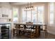 Dining room with a large table, modern lighting, and large windows with white shutters at 25454 N 73Rd Ave, Peoria, AZ 85383