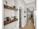 Beautiful hallway with custom floating wood shelves, light grey paint and wood floors with arches at 25454 N 73Rd Ave, Peoria, AZ 85383