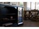 Dark colored kitchen island features open shelves and wine fridge, connecting to adjacent dining table at 25454 N 73Rd Ave, Peoria, AZ 85383