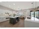 Open layout kitchen showcasing an island with a wine cooler, white cabinets and a dining table at 25454 N 73Rd Ave, Peoria, AZ 85383