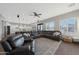 Open-concept living room with a leather sectional, wood floors, and backyard views at 25454 N 73Rd Ave, Peoria, AZ 85383