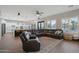 Open-concept living room with wood floors, a comfortable leather sofa, and a view of the backyard at 25454 N 73Rd Ave, Peoria, AZ 85383