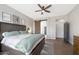Main bedroom with a king bed, wood-look floors, ceiling fan, and ensuite bathroom at 25454 N 73Rd Ave, Peoria, AZ 85383