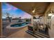 Inviting outdoor patio with a refreshing pool, comfortable seating, and lush landscaping at dusk at 25454 N 73Rd Ave, Peoria, AZ 85383