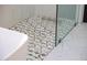 Detailed view of shower floor with geometric tile, glass and marble walls at 25454 N 73Rd Ave, Peoria, AZ 85383