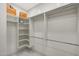 Bright walk-in closet with custom shelving, hanging rods and marble floors provides ample storage space at 25454 N 73Rd Ave, Peoria, AZ 85383