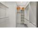 Bright walk-in closet with custom shelving, hanging rods and marble floors provides ample storage space at 25454 N 73Rd Ave, Peoria, AZ 85383