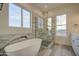 Bright bathroom featuring a soaking tub, glass enclosed shower, and large window for natural light at 28003 N Faded Creek Dr, Florence, AZ 85132