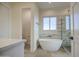 Bright bathroom with free standing tub, glass shower, and a view from the window at 28003 N Faded Creek Dr, Florence, AZ 85132