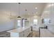 An open-concept living space with a kitchen featuring stainless steel appliances, white cabinetry, and a large island at 28003 N Faded Creek Dr, Florence, AZ 85132