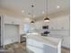 An open kitchen with stainless steel appliances, white cabinetry, a large island, and modern pendant lighting at 28003 N Faded Creek Dr, Florence, AZ 85132