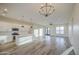 Open floor plan featuring a kitchen with white cabinets, and a spacious living room with wood-look tile flooring at 28003 N Faded Creek Dr, Florence, AZ 85132