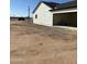 Side view of a home with an open garage, showcasing the spacious driveway and access to the house at 28003 N Faded Creek Dr, Florence, AZ 85132