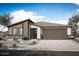 A modern single-story home boasts desert landscaping, a two-car garage, and a stylish blend of materials at 28926 N 173Rd Dr, Surprise, AZ 85387