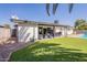 Serene backyard showcasing a covered patio, lush artificial grass, and access to a refreshing pool for outdoor enjoyment at 3015 E Dahlia Dr, Phoenix, AZ 85032