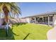 Expansive backyard featuring lush artificial grass, a covered patio, and a tranquil area for relaxation and entertainment at 3015 E Dahlia Dr, Phoenix, AZ 85032