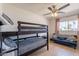 Bright bedroom featuring a bunk bed, ceiling fan, and comfortable blue couch at 3015 E Dahlia Dr, Phoenix, AZ 85032