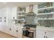 This kitchen showcases stainless appliances, white cabinets, a gas range and a unique backsplash with floating shelves at 3015 E Dahlia Dr, Phoenix, AZ 85032