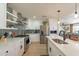 Well-lit kitchen with modern white cabinets, stainless steel appliances, and stylish backsplash with floating shelves at 3015 E Dahlia Dr, Phoenix, AZ 85032