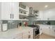 This kitchen showcases white cabinets, stainless steel appliances, and a unique backsplash with open shelving at 3015 E Dahlia Dr, Phoenix, AZ 85032