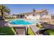 Inviting backyard oasis featuring a sparkling pool, lounge chairs, lush artificial grass, and a charming patio area at 3015 E Dahlia Dr, Phoenix, AZ 85032