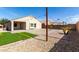 An outdoor patio space with artificial turf, gravel landscaping, and string lights is ready for entertaining at 40049 W Hopper Dr, Maricopa, AZ 85138