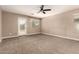 Spacious bedroom featuring plush carpeting, natural light, and a ceiling fan at 40049 W Hopper Dr, Maricopa, AZ 85138