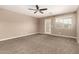 Bright bedroom featuring plush carpeting, natural light, and a ceiling fan at 40049 W Hopper Dr, Maricopa, AZ 85138