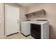 Convenient laundry room features modern appliances and overhead shelving at 40049 W Hopper Dr, Maricopa, AZ 85138