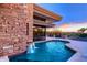 Beautiful pool area with a stone wall, a waterfall feature, and an outdoor dining space at 40478 N 108Th Pl, Scottsdale, AZ 85262
