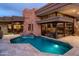 Stunning backyard with a sparkling pool, stone accents, and an elegant fountain feature at dusk at 40478 N 108Th Pl, Scottsdale, AZ 85262