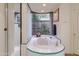 Elegant bathroom with a soaking tub, a shower, and a view of the greenery outside at 40478 N 108Th Pl, Scottsdale, AZ 85262