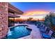 Beautiful pool with a stone waterfall feature, surrounded by lounge seating and desert landscape at 40478 N 108Th Pl, Scottsdale, AZ 85262