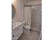 Stylishly remodeled bathroom featuring modern white vanity, round mirror, and tiled shower with glass door at 4304 N Parkway Ave, Scottsdale, AZ 85251