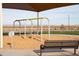 Community playground featuring swings, a bench, and a soft landing surface under a shade structure at 4661 E French Rd, San Tan Valley, AZ 85143