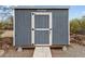 Exterior view of shed, featuring a white door and painted in coordinating colors at 49011 N 7Th Ave, New River, AZ 85087