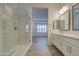 Bright bathroom with a glass-enclosed shower and double sinks with a view of the bedroom at 5650 E Scarlet St, Mesa, AZ 85215
