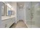 Elegant bathroom featuring double sinks, wood-look tile flooring, and a glass-enclosed shower at 5650 E Scarlet St, Mesa, AZ 85215