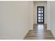Inviting entryway showcasing stylish wood-look flooring and a modern black front door with glass panels at 5650 E Scarlet St, Mesa, AZ 85215