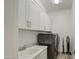 A functional laundry room has a sink, sleek cabinets, and modern washer/dryer at 5650 E Scarlet St, Mesa, AZ 85215