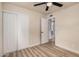 A bright bedroom features wood-look floors, a closet with sliding doors, and a ceiling fan at 6265 W Mariposa St, Phoenix, AZ 85033