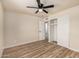 The bright bedroom features wood-look floors, a closet with sliding doors, and a ceiling fan at 6265 W Mariposa St, Phoenix, AZ 85033