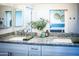 Modern bathroom with granite countertop, dual sinks, and decorative plants at 7531 E Billings St # 132, Mesa, AZ 85207