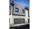 Modern two-story home with gray wood-look panels, gray garage door, and concrete walls at 7531 E Billings St # 132, Mesa, AZ 85207