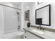 Bathroom with a shower-tub combo, white subway tiles, modern fixtures, and a framed mirror at 804 E Palmaire Ave, Phoenix, AZ 85020