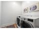 Modern laundry room with front-loading washer and dryer units and minimalist wall art at 804 E Palmaire Ave, Phoenix, AZ 85020