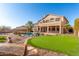 Expansive backyard with swimming pool, putting green, desert landscaping, and covered patio at 8219 E Tesoro Cir, Mesa, AZ 85207