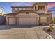 Three car garage featuring stone facade and modern garage doors at 8219 E Tesoro Cir, Mesa, AZ 85207
