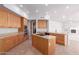 Bright kitchen with granite countertops, tan cabinets, and center island with a gas cooktop at 8219 E Tesoro Cir, Mesa, AZ 85207